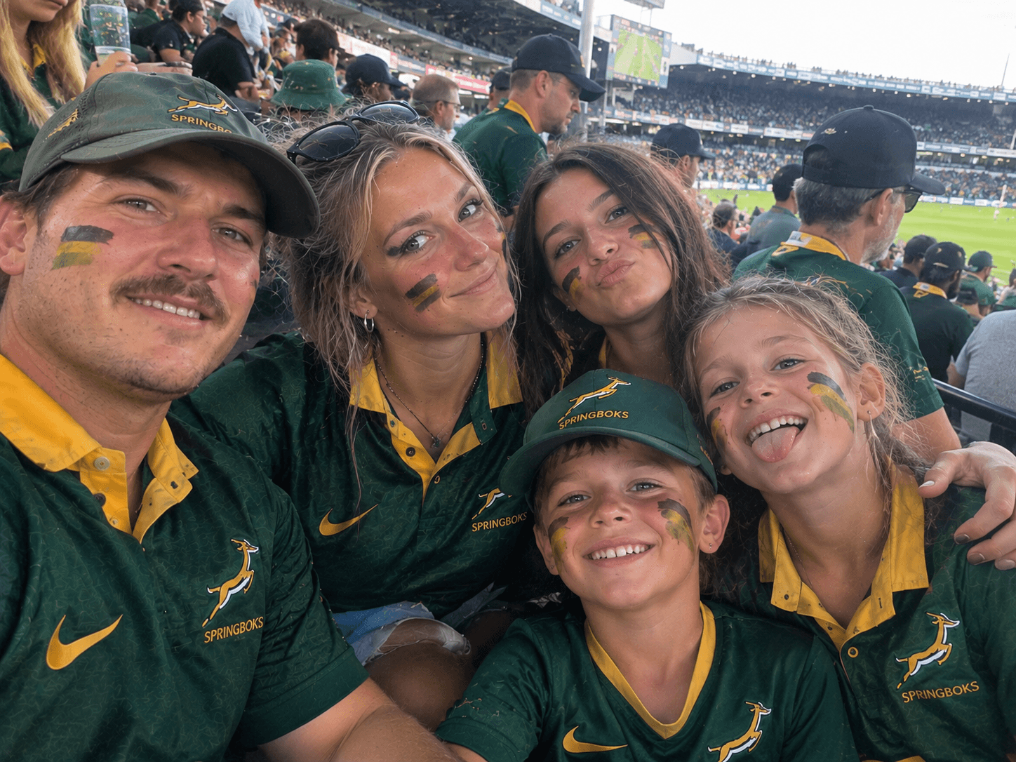 Family in Springbok jerseys with face paint at the stadium