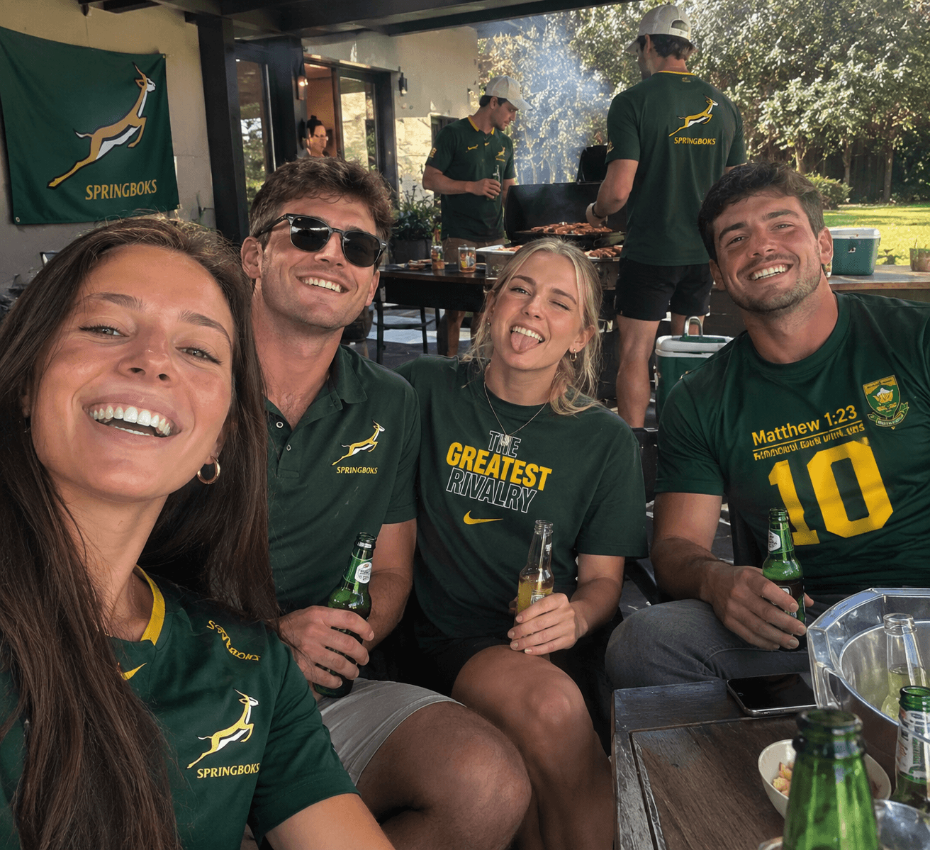 Friends taking a selfie at a backyard braai in Springbok shirts