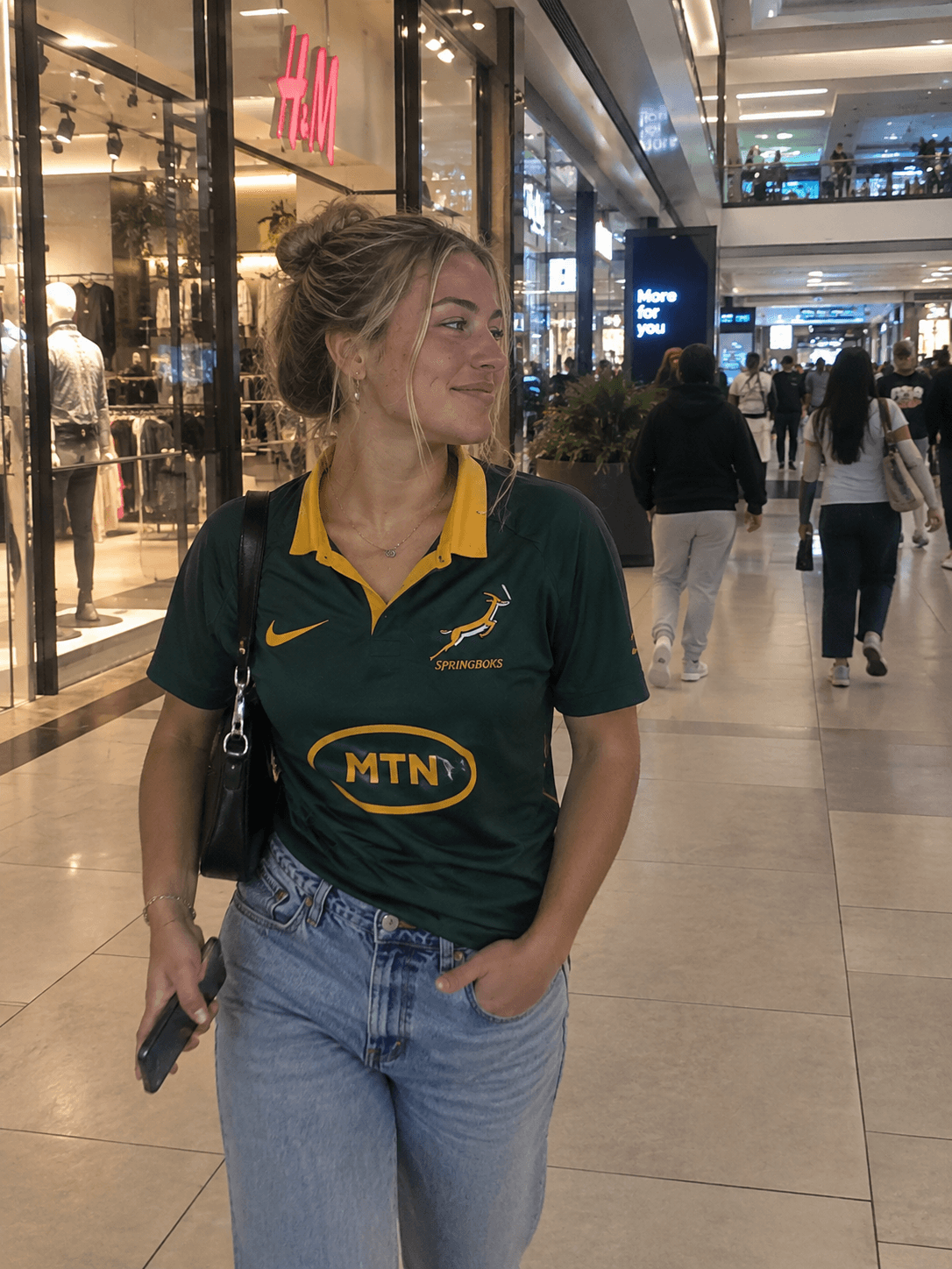 Woman in a Springbok jersey walking through a shopping mall